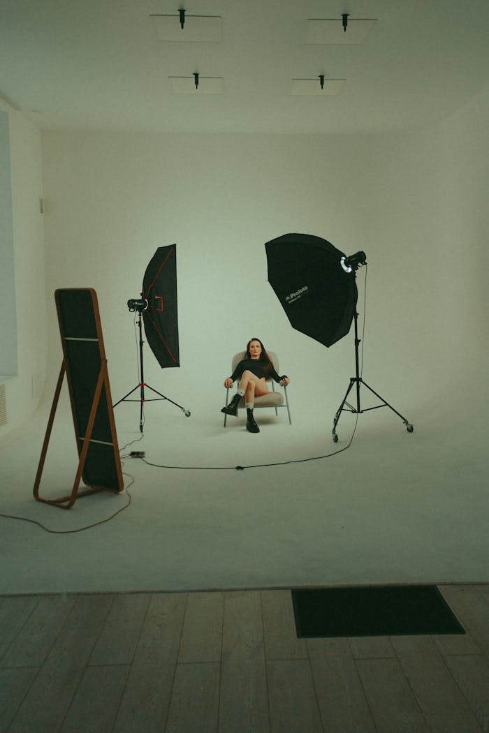 Woman posing in a professional photography studio setting surrounded by lighting.
